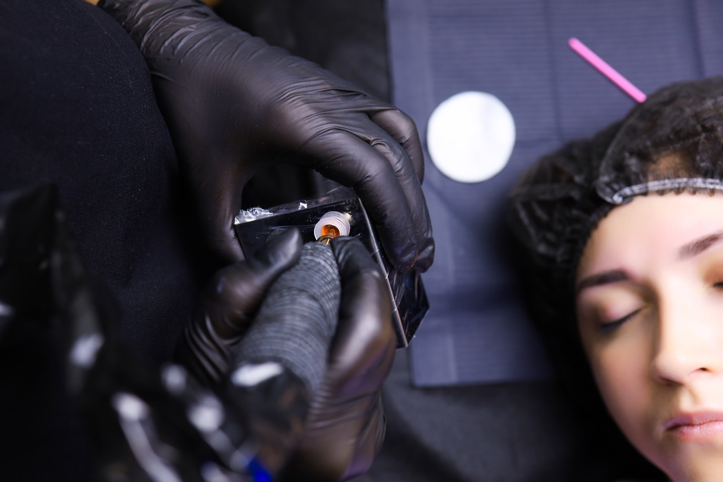 Master Tattoo Artist Dials the Pigment from the Cap of the Tatto